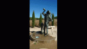 Pilgrim statue drinking at water fountain.gif