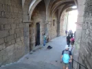 2 Oct #20 1258hrs Santiago de Compostela Pat walking past busker in Arco Arzobispal on Rua Az...webp